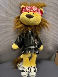 Ozzy the lion puppet dressed in rock clothes