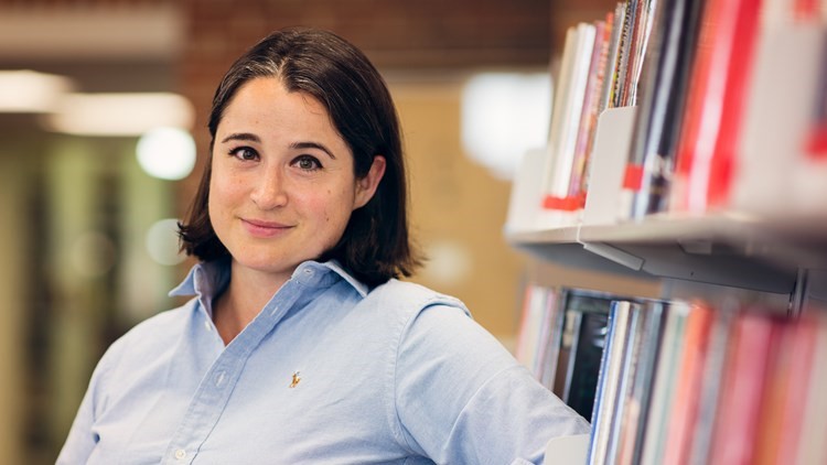Woman next to a bookshelf in the library