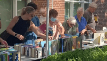 Customers shop the Friends Summer Book Sale outside